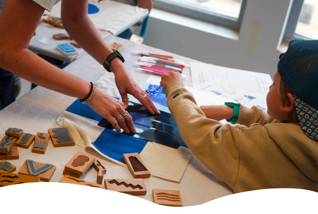 Atelier créatif entre une adulte et un enfant dans une école, lors d’une journée de sensibilisation aux Rencontres du Littoral.